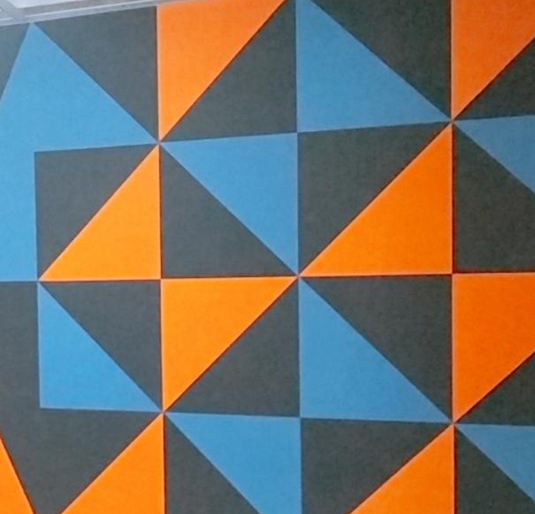 Triangular acoustic panels in orange, blue and grey