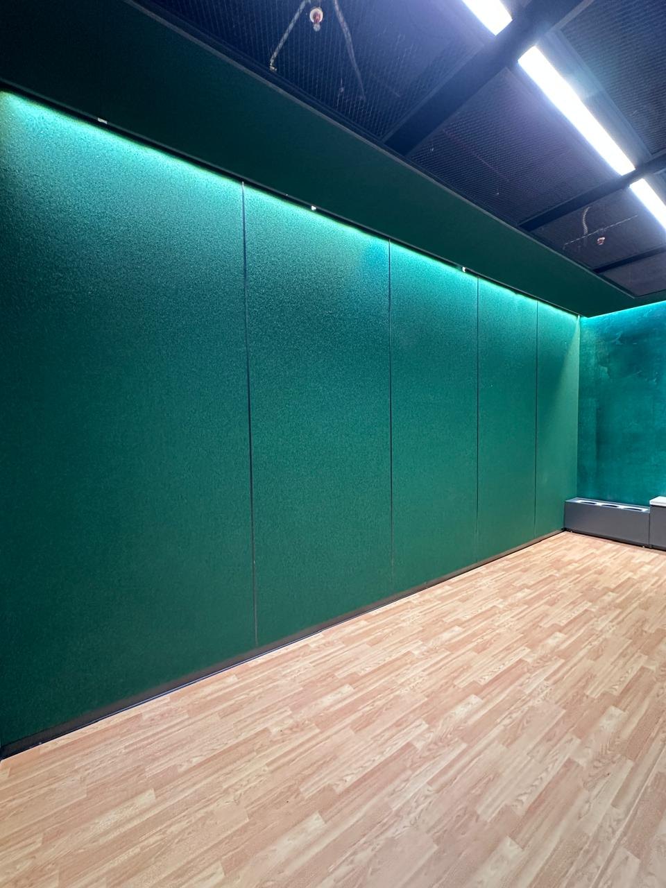 Teal acoustic wall panels with concealed cove lighting
